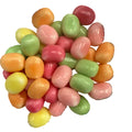 Colorful jelly beans in pink, green, and orange on a white background